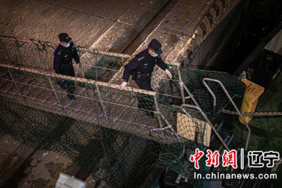 2月3日，在大连辽渔船埠，民警正登上“沃尔”轮为其操持出境手续。